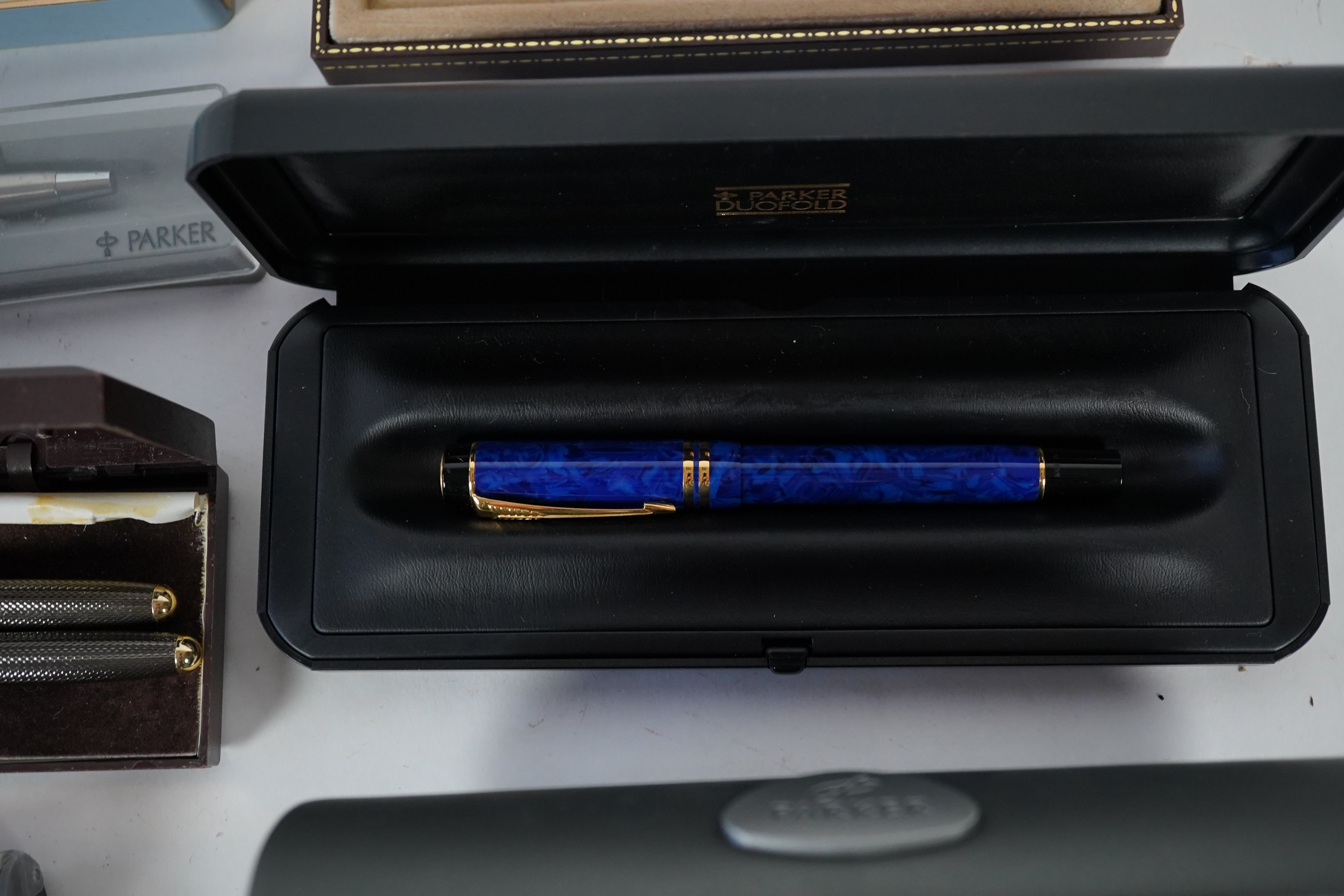 A cased Parker duofold ballpoint pen, a cased Parker Sonnet lacquer ruby red fountain pen, a Dunhill gold plated fountain pen and various fountain pens and ballpoint pens including Parker, Sheaffer, Quill, etc.